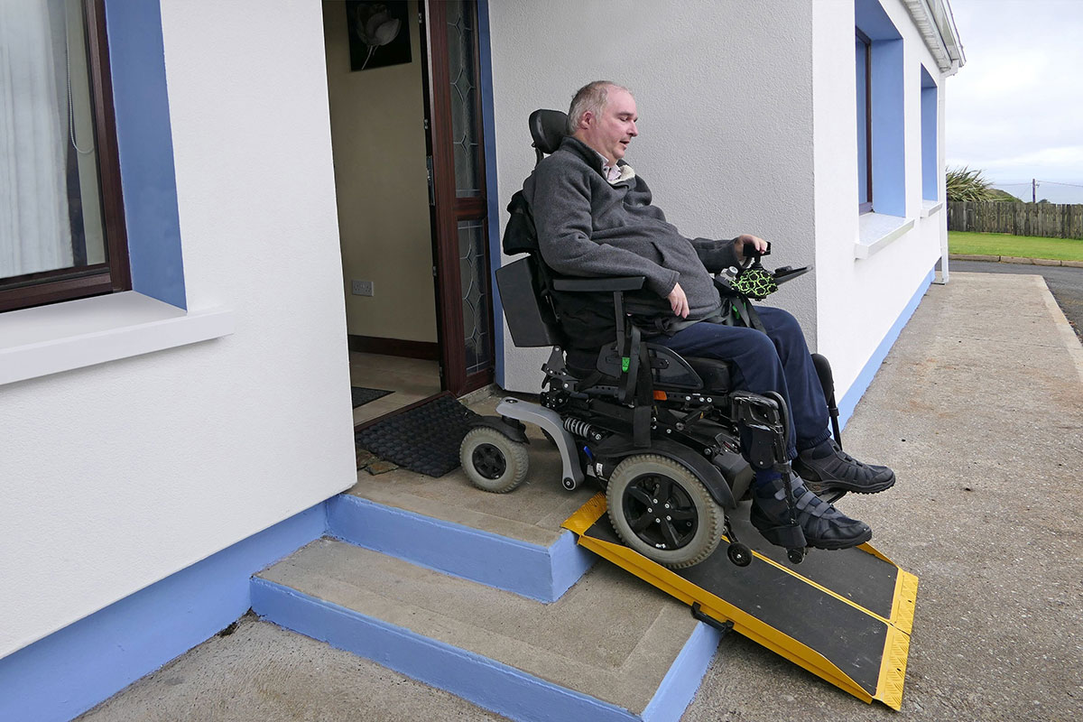 Man in wheelchair using a ramp in a specialist disability accomodation